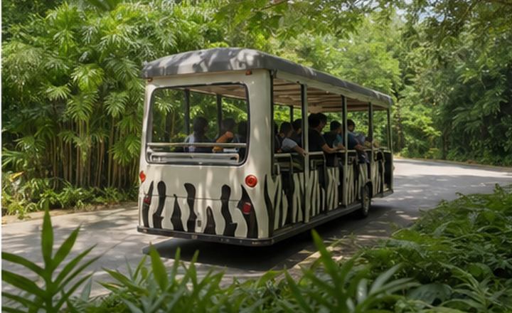 Tram moving through green zoo grounds
